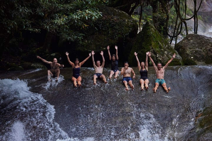 A group riding skis in the Natural Rock Slide Josephine Falls