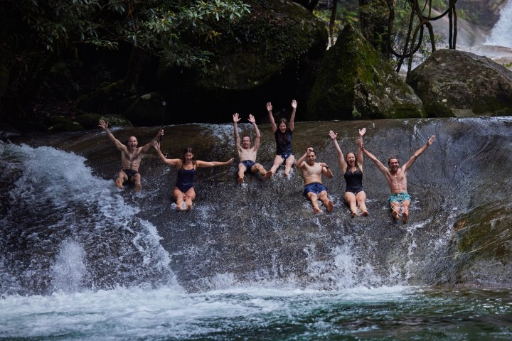 A group riding skis in the Natural Rock Slide Josephine Falls