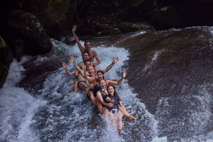 People having fun in the Natural Rock Slide Josephine Falls