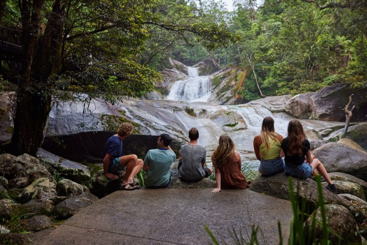 people sitting on a rock in front of Josephine Falls