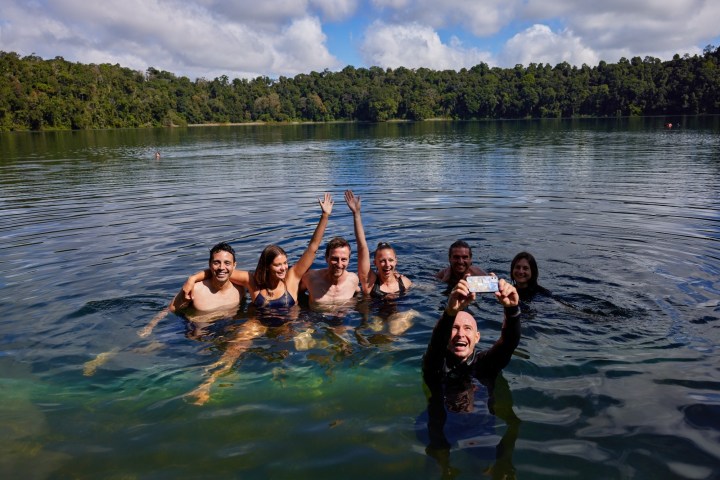A group swimming in Lake Eacham on a day tour of Cairns