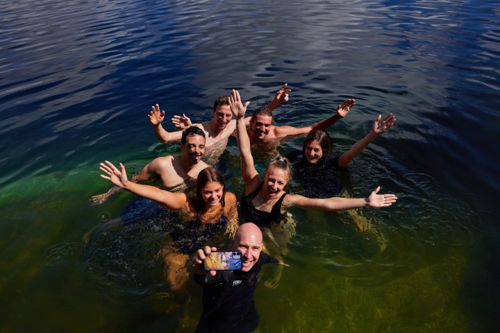 A group swimming in Lake Eacham on a day tour of Cairns