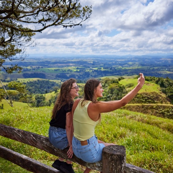 Group of people sitting on a wooden fence at Milla Milla Lookout