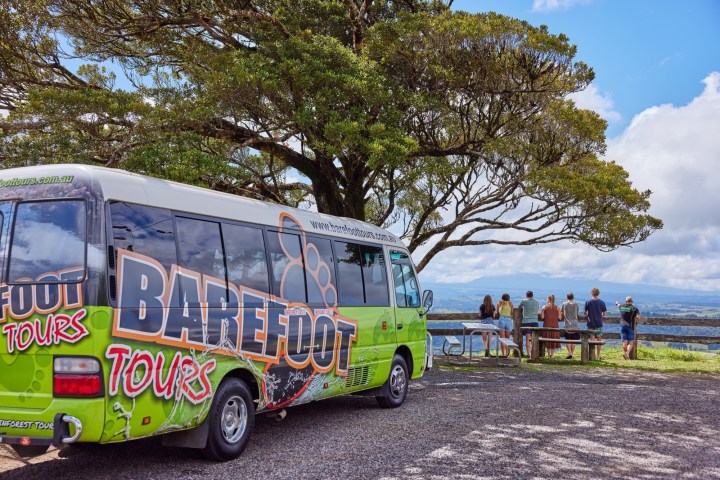 Colorful Barefoot Bus Cairns from Tours parked at a park