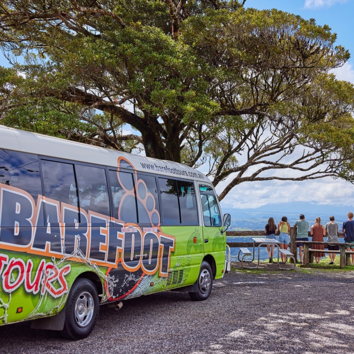 Colorful Barefoot Bus Cairns from Tours parked at a park