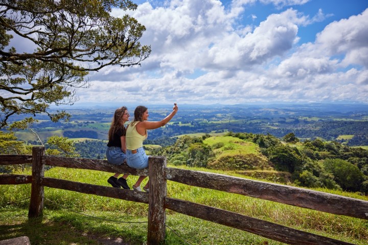 Two people sitting on a wooden fence at Milla Milla Lookout